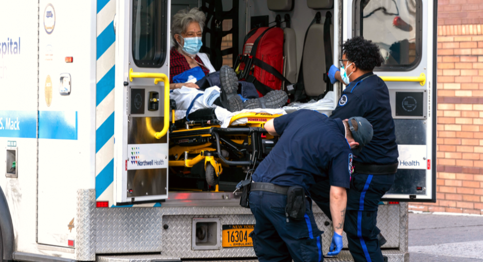 A COVID-19 patient in an ambulance with two emergency technicians