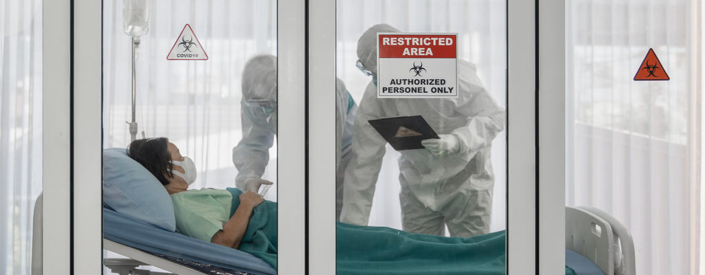 health care workers in hazmat suits with COVID-19 patient