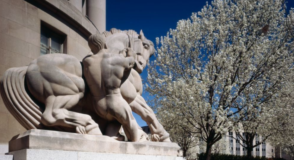 sculpture of a man and horse outside a federal building