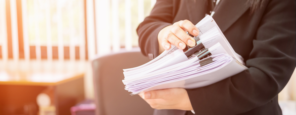 office worker holding a stack of papers