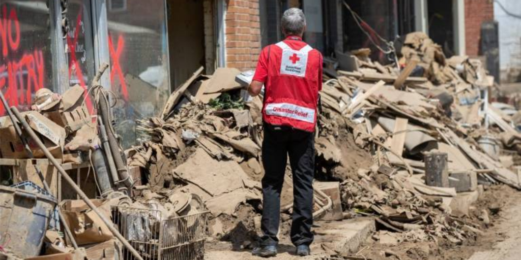 American Red Cross disaster relief worker standing in debris