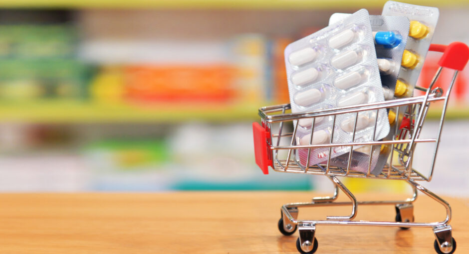 Image of miniature shopping cart and medicine blister packs