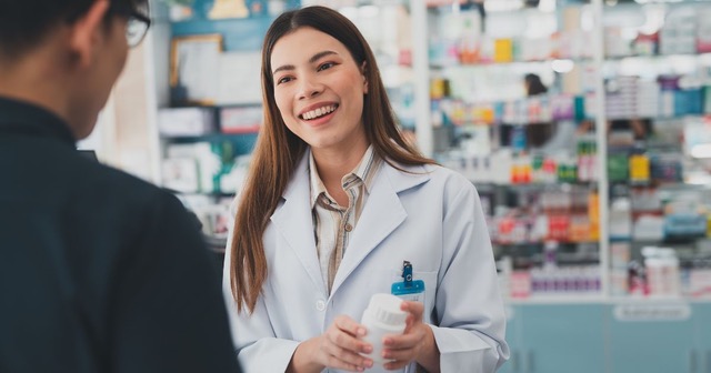 Pharmacist dispenses prescription to customer